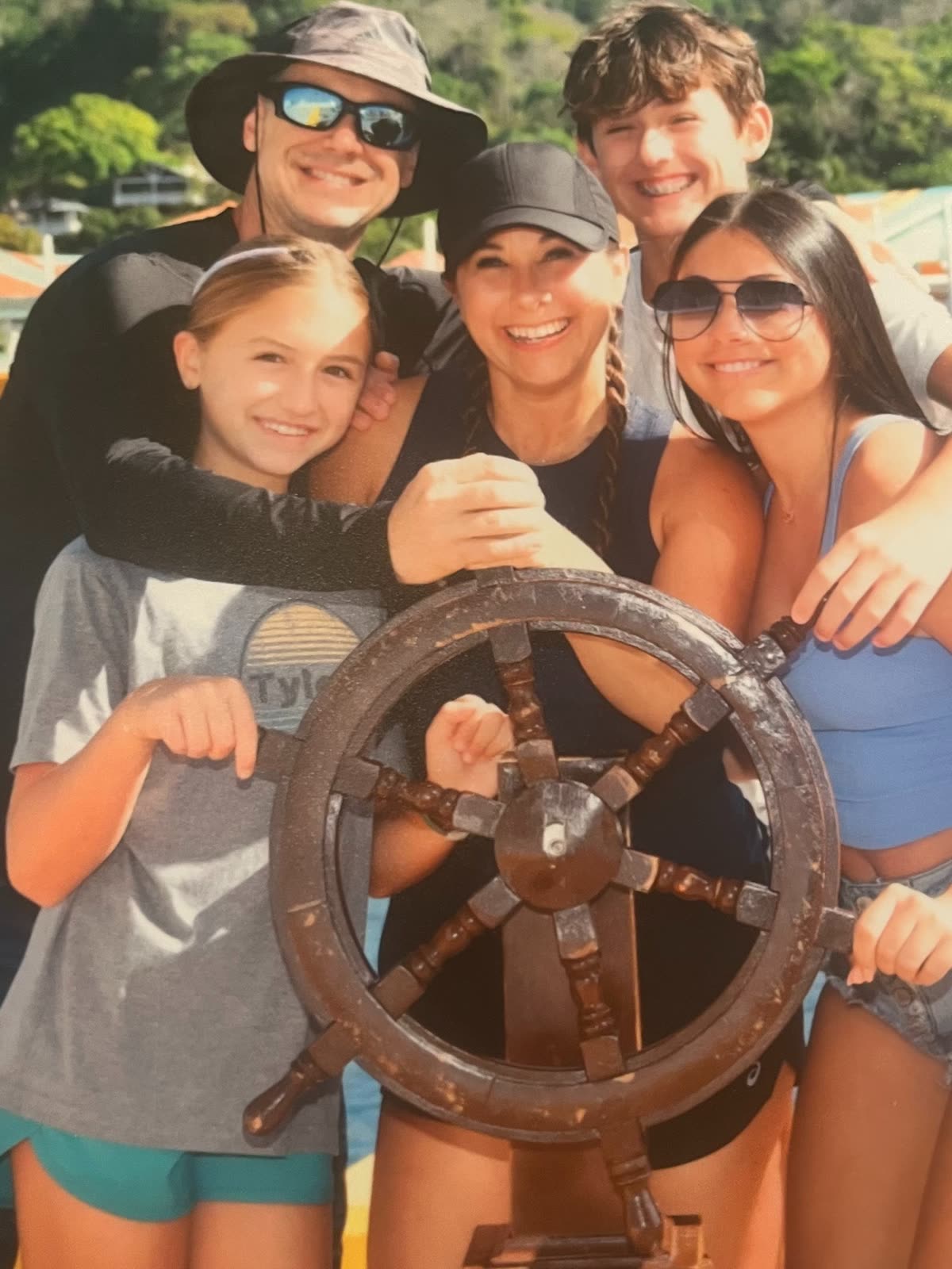 Carly, Brandon and the four children gathered together on a boat during a family trip.